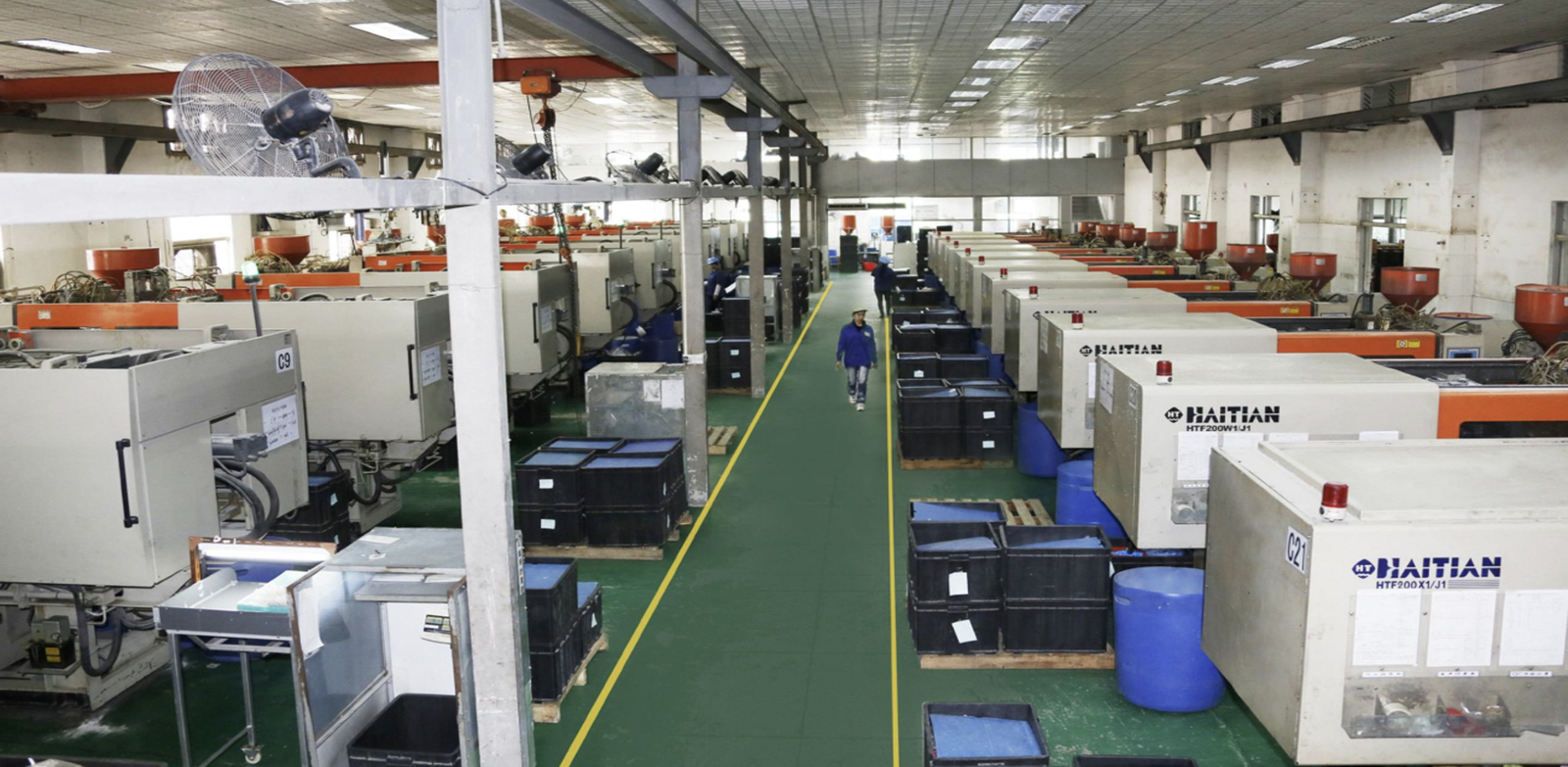Injection molding workshop with multiple production machines running plastic parts