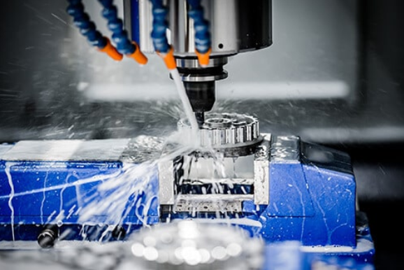 Five-axis CNC machining centre cutting an aluminium part with coolant
